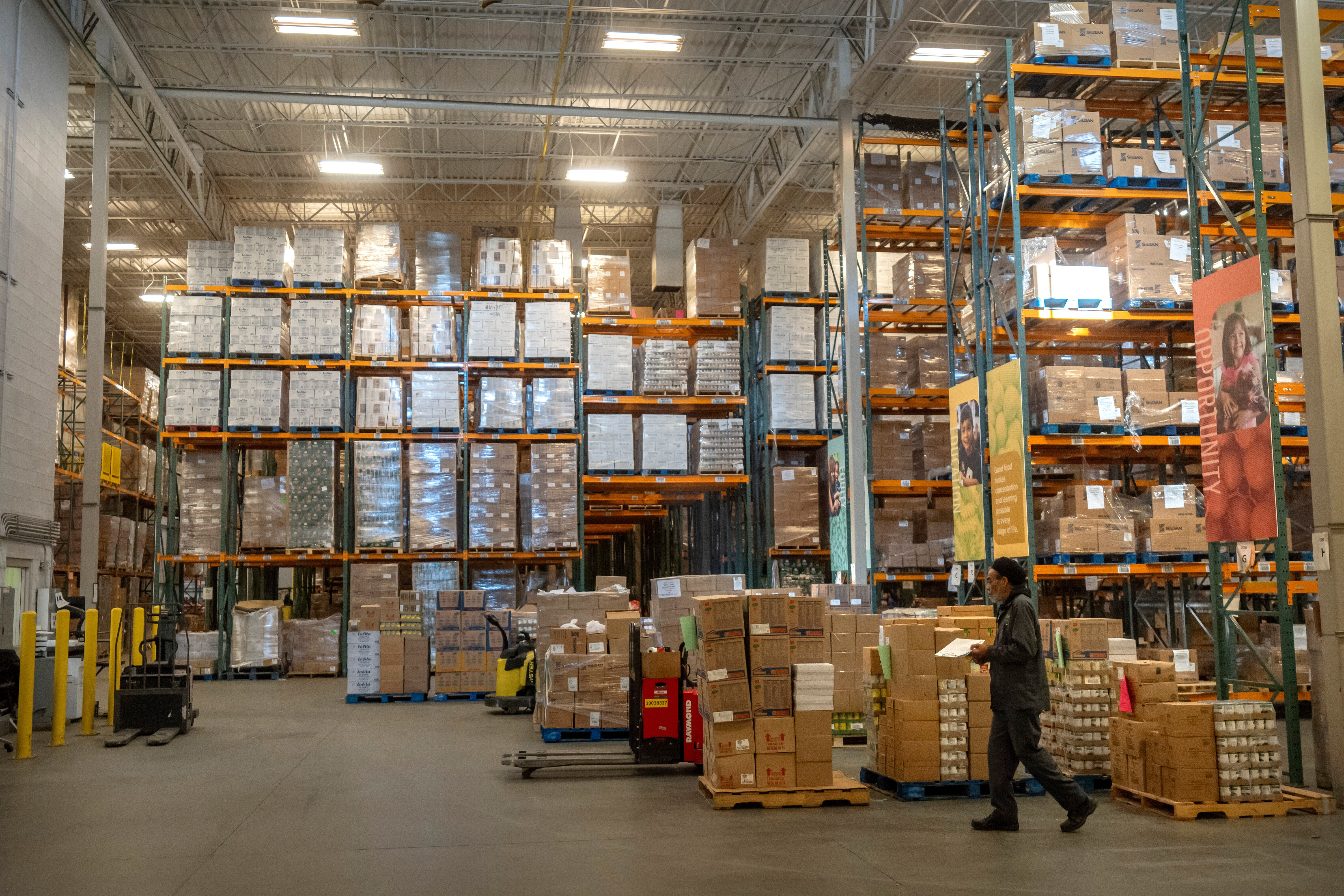 An employee walks past pallets of nonperishable food at a warehouse of the Capital Area Food Bank, Thursday, Nov. 6, 2025, in Washington.